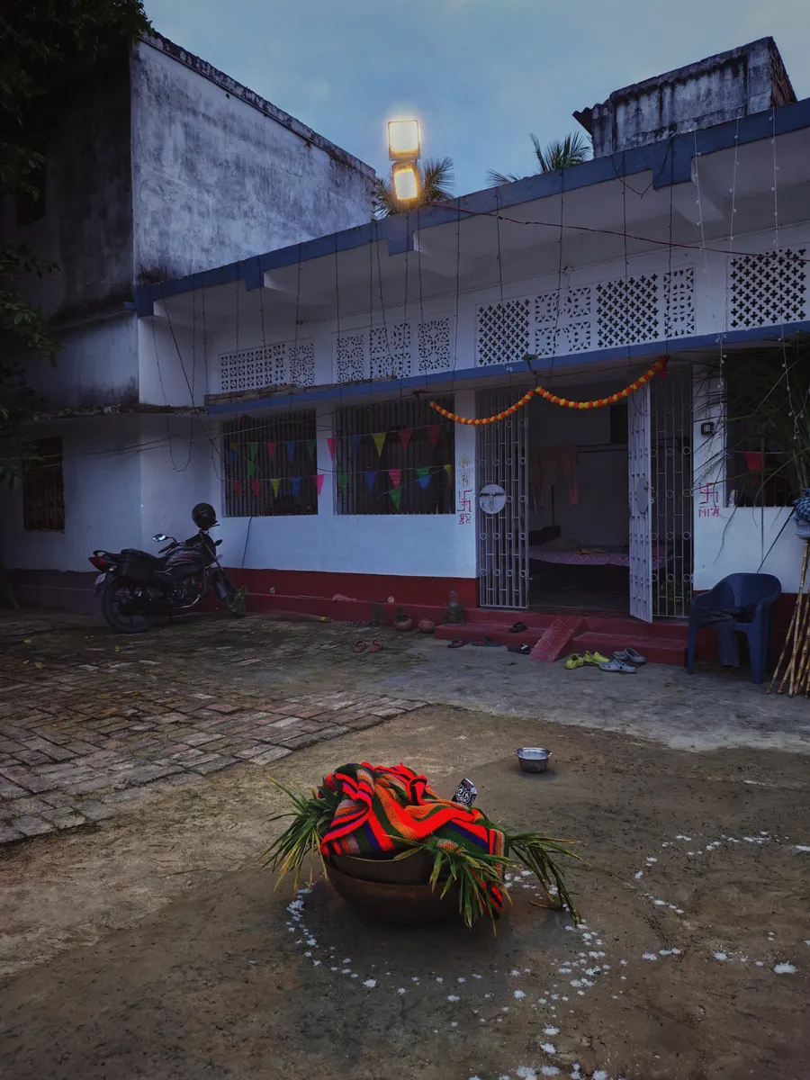 A courtyard with a decorated basket in front of a house.